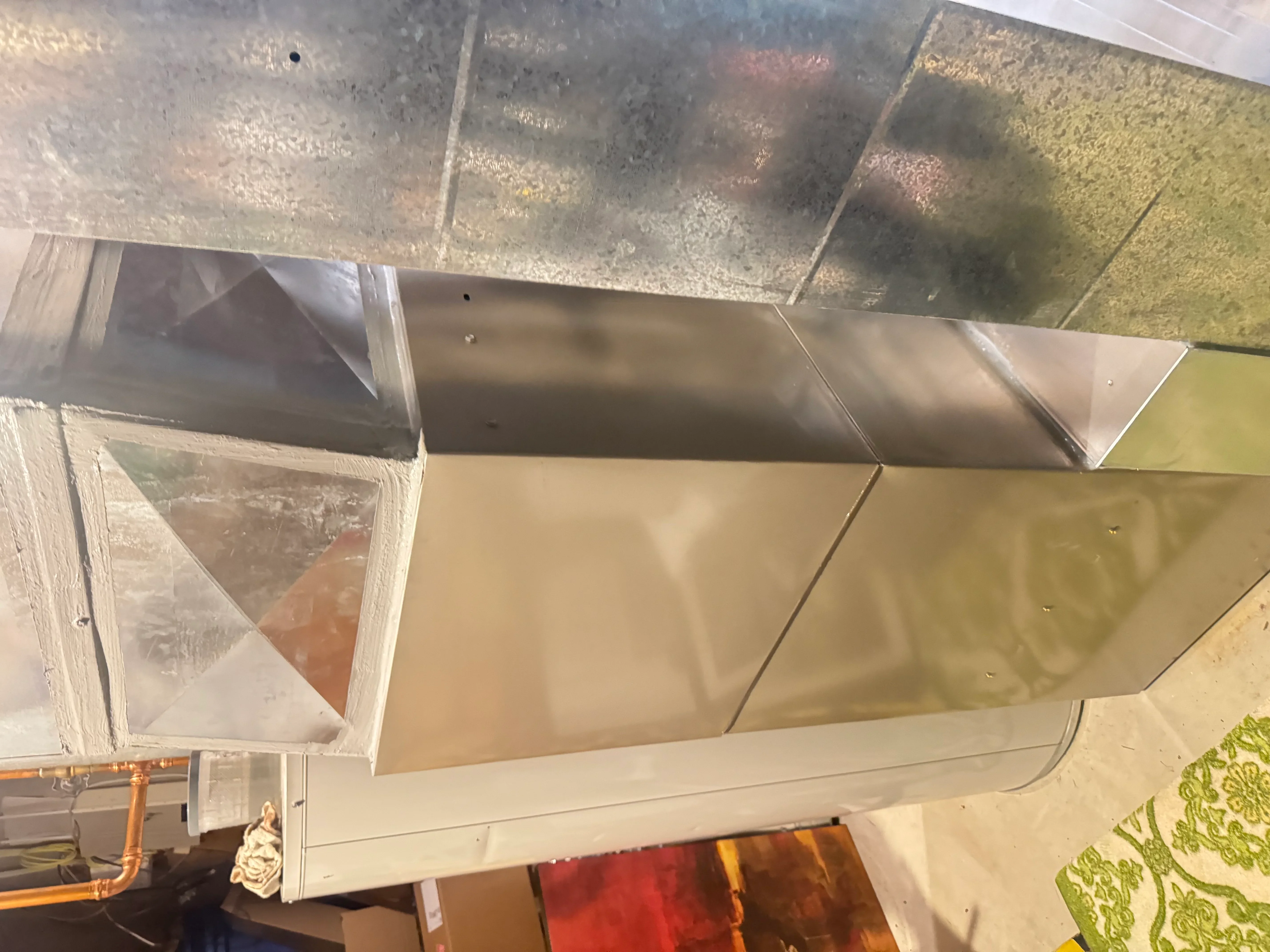 Metal ductwork installation with insulated ducts and sealed connections in ceiling cavity