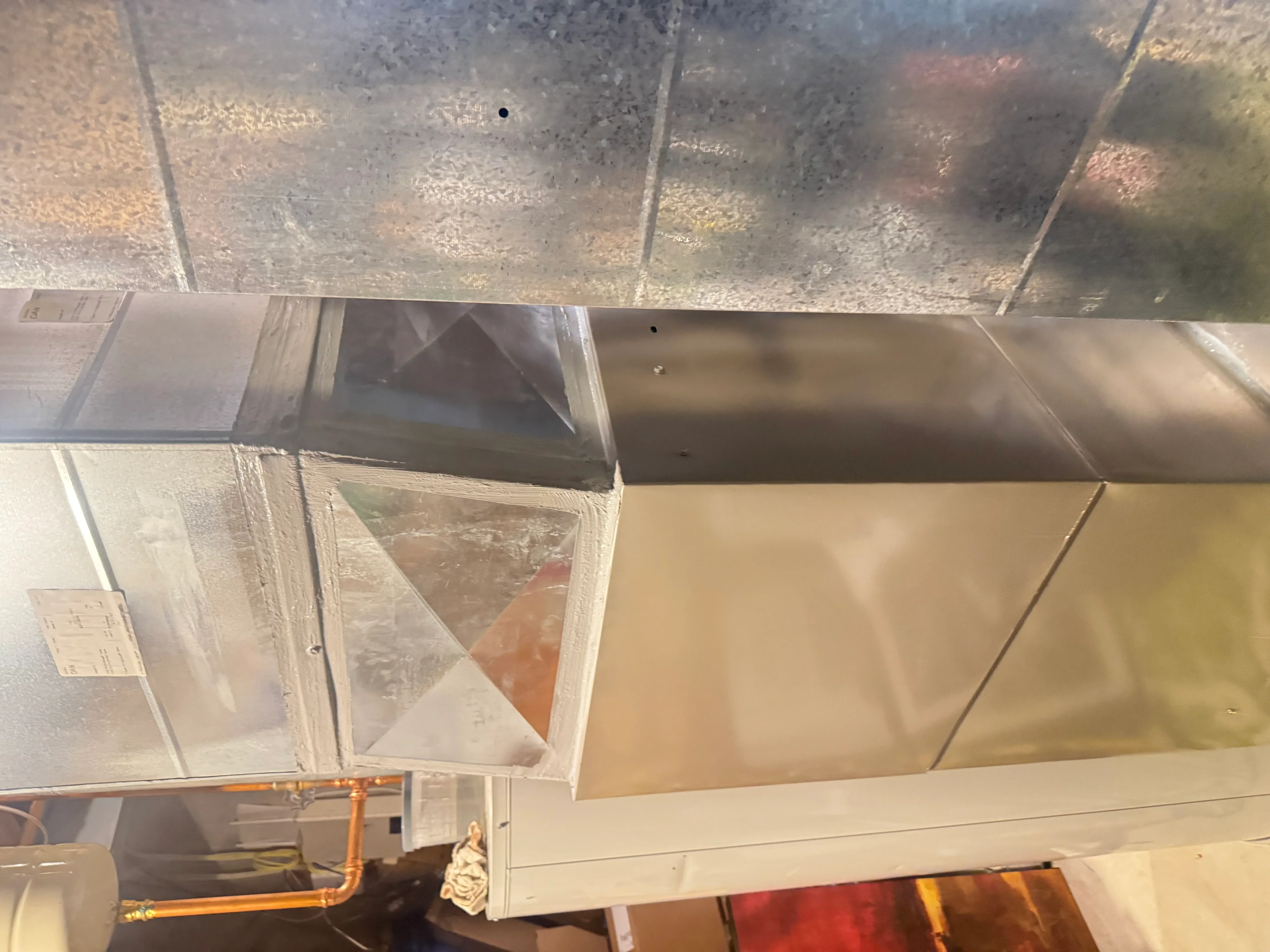 Metal ductwork with sealed joints, mastic sealant, and copper refrigerant lines installed
