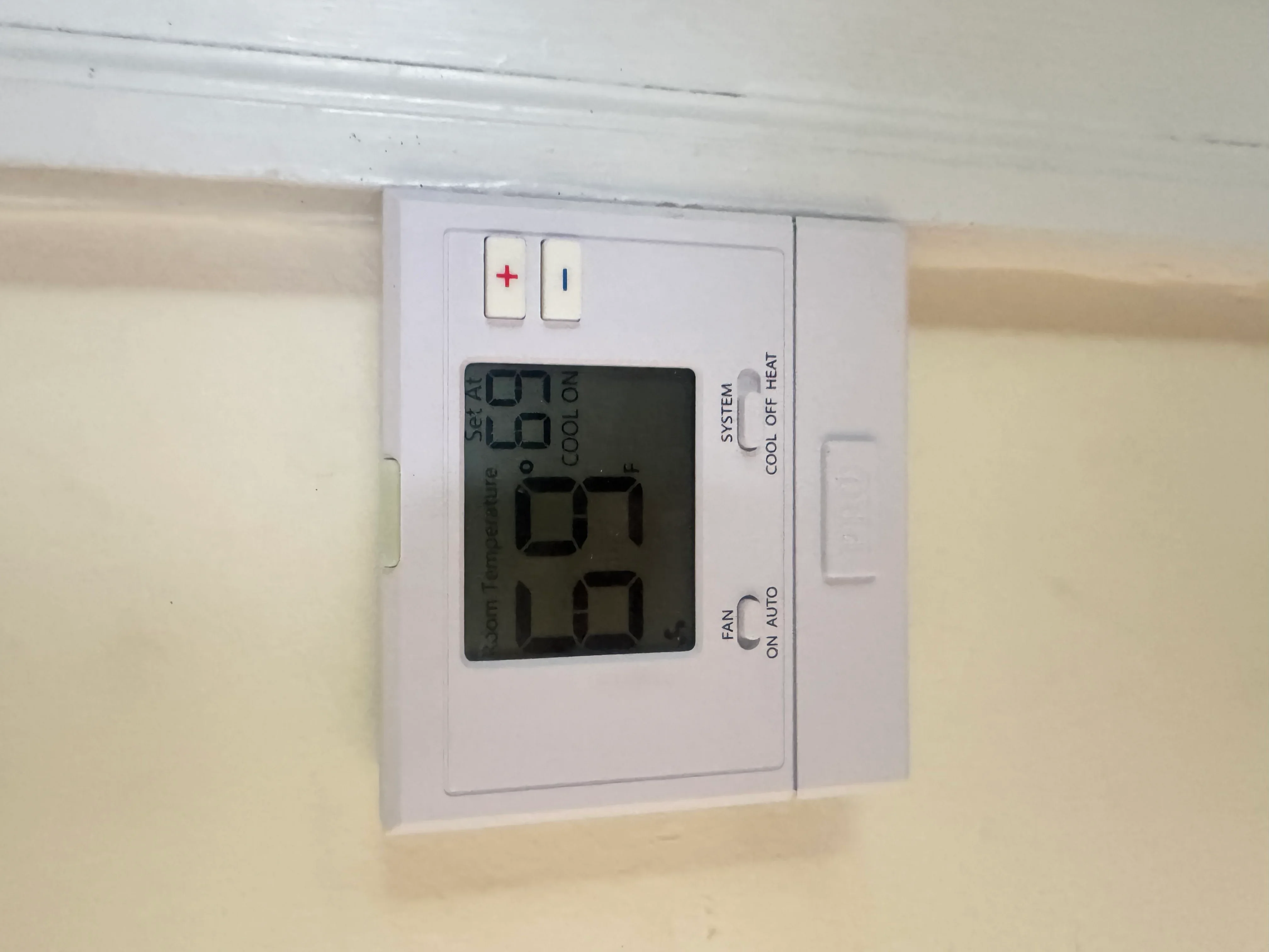 White programmable thermostat with digital display showing temperature and system controls
